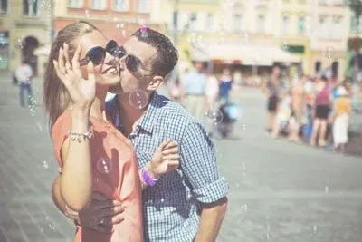 Man kissing woman surrounded by bubbles