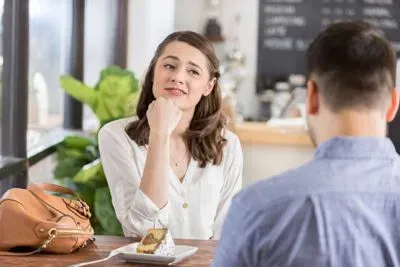 Couple on a blind date in a Chicago cafe. The woman looks uncertain about her match.