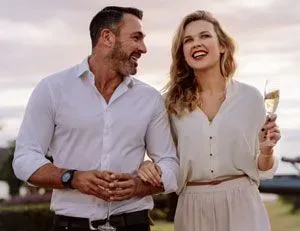 Couple drinking champagne outside and smiling