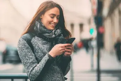 Woman checking luxy app on her phone and smiling