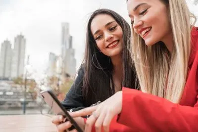 Two girls looking at profiles on a mobile