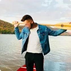 Man holding a paddle near his kayak in a Hinge pic