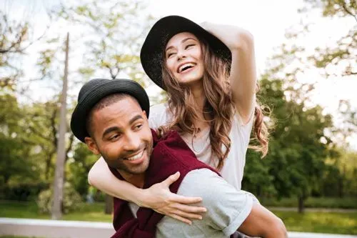 Happy matches, a man giving a piggy back ride to a woman he's dating
