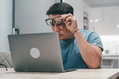 Man looking puzzled at laptop trying to figure out Tinder Web