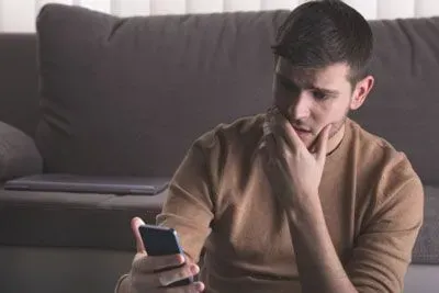 Man looking puzzled at Hinge on phone