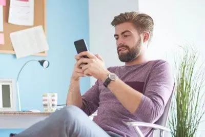 Man texting from his home office chair