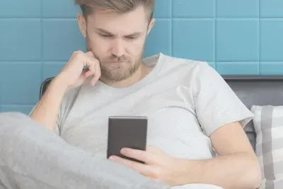 Man thinking about what kind of text to send a girl