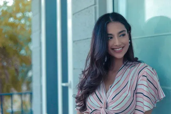 Pretty young woman standing outside a building and smiling