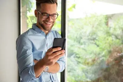 Smiling man texting a Hinge match