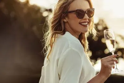Sophisticated woman drinking champagne outside