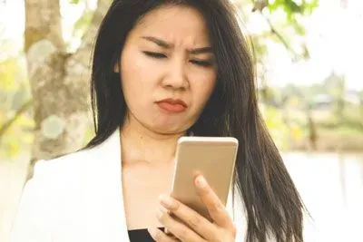 Woman frowning at her Hinge profile