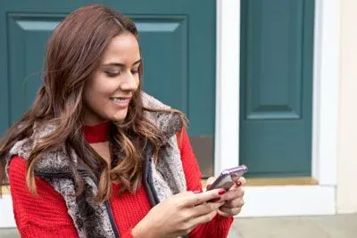 Woman smiling and reading a message on Match.com app