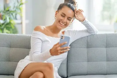 Woman smiling while looking at Hinge app