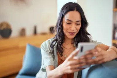 Woman smiling at Tinder app on her phone