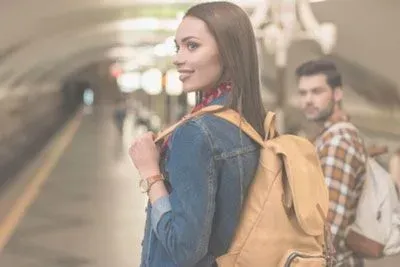 Man checking out a woman as they're waiting for the train
